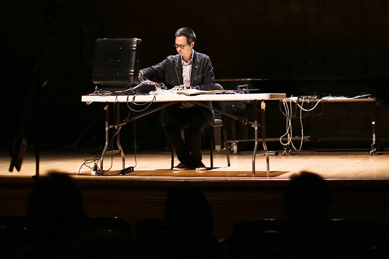 A musician performs an electronic composition as part of the Songlines concert series hosted by Mills Performing Arts.