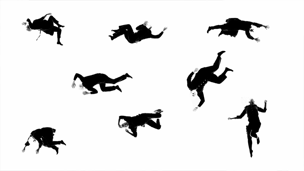 A black and white abstract image with eight human full human figures, spread evenly in three rows across a white field. The bodies are filtered as though they are a photo negative, their postures varied from flat on the back arms and legs extended, to curled on their side. Elbows and knees are bent creating unique shapes. Still from "Rotation" video, from "Indra's Net" by Meredith Monk Camera, editing: Ben Stechshulte. Direction: Meredith Monk