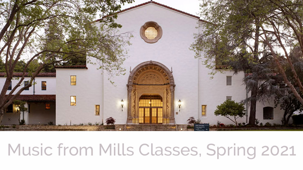 A photo of the front of the Music Building, a grand facade in the spanish colonial style build in 1928, sits in the lavendar magic hour of twilight, on the Mills College campus in Oakland California.