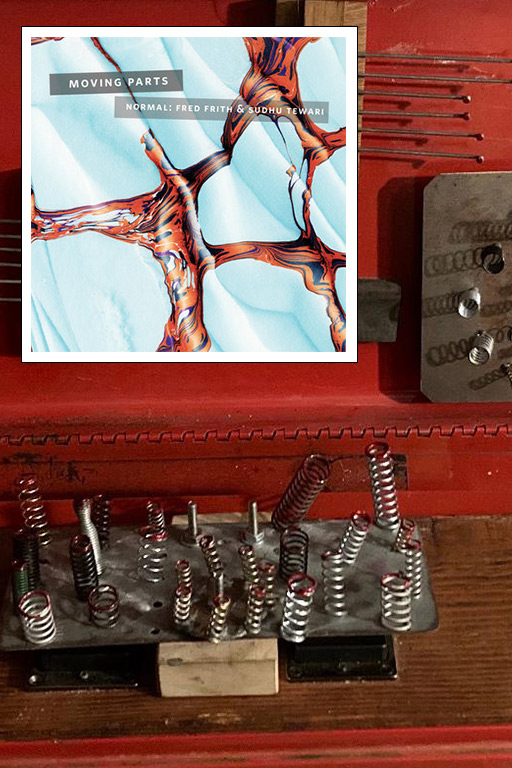 A color photograph of a red box filled with springs and metal wires, with the cover of the record "Moving Parts" featuring marbled red shapes on a light blue surface overlaid. Photo courtesy of Sudhu Tewari. Record cover courtesy of fo'c's'le music. 